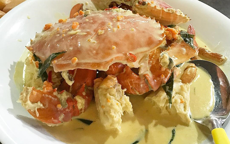 A whole crab with creamy butter sauce on a plate